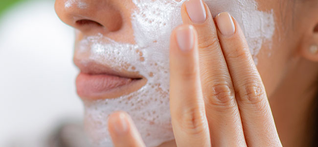 Una persona aplicándose exfoliante facial